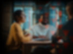 A group of people talking at an office setting in a meeting with a glass background