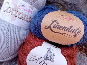 Cotton, linen and alpaca yarns arranged together outdoors to illustrate natural alternatives to wool.