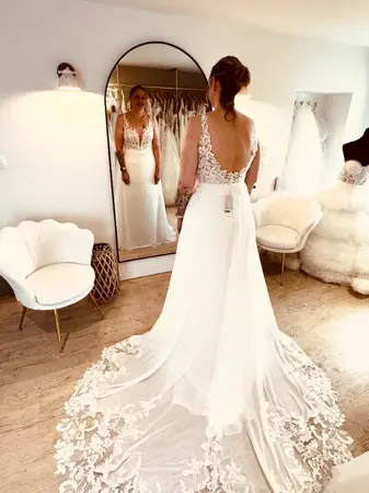 Essayage robe de mariée dos nu en dentelle avec traîne fluide élégante à Aire-sur-la-Lys en boutique spécialisée proche Saint-Omer