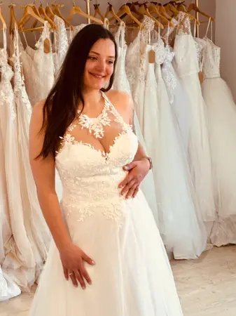 Future mariée portant une robe de mariée seconde main princesse en dentelle à Béthune en boutique spécialisée