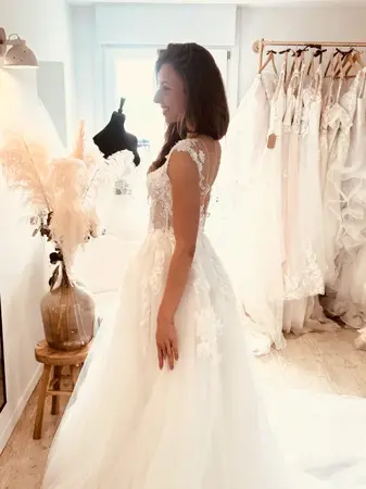 Robe de mariée d’occasion en dentelle fluide vue de profil essayée en boutique dans le Pas-de-Calais