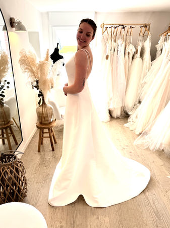 Essayage robe de mariée en satin fluide avec longue traîne à Aire-sur-la-Lys dans une boutique spécialisée proche Saint-Omer