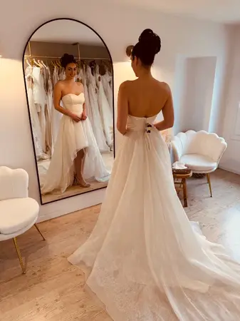 Essayage robe de mariée seconde main fluide avec dos nu et traîne légère à Béthune en boutique spécialisée