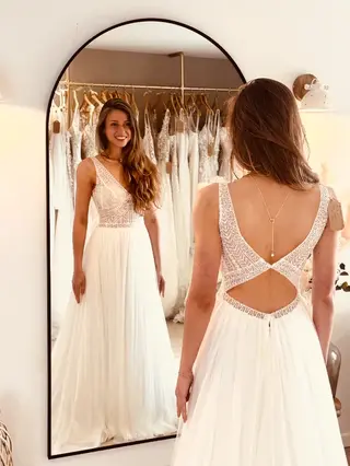 Essayage robe de mariée seconde main avec dos croisé et jupe fluide en dentelle à Béthune en boutique spécialisée