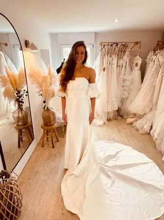 Essayage robe de mariée seconde main fluide avec bustier et longue traîne à Aire-sur-la-Lys en boutique spécialisée proche Saint-Omer