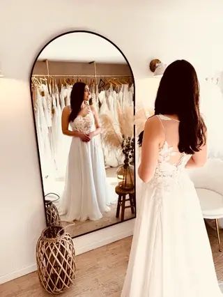 Essayage robe de mariée seconde main fluide avec dos nu élégant et traîne légère à Béthune en boutique spécialisée