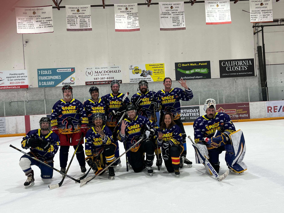 Beer league hockey team posing on the ice wearing blue Space Invaders themed custom jerseys designed by Beer League Custom.