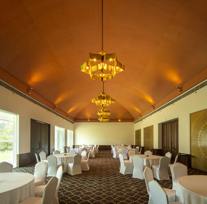 Best banquet hall in India, banquet hall interior design, terracotta ceiling, pointed arch ceiling design, vaulted ceiling interior design, round table seating in a banquet, lotus shaped ceiling lights, Buddhism inspired hotel interior design
