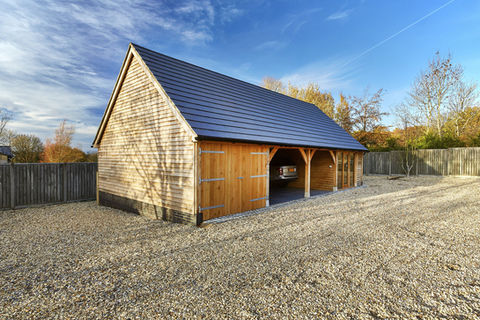 A Hartwood oak garage in Berkshire, showcasing a car parked within its wooden structure.