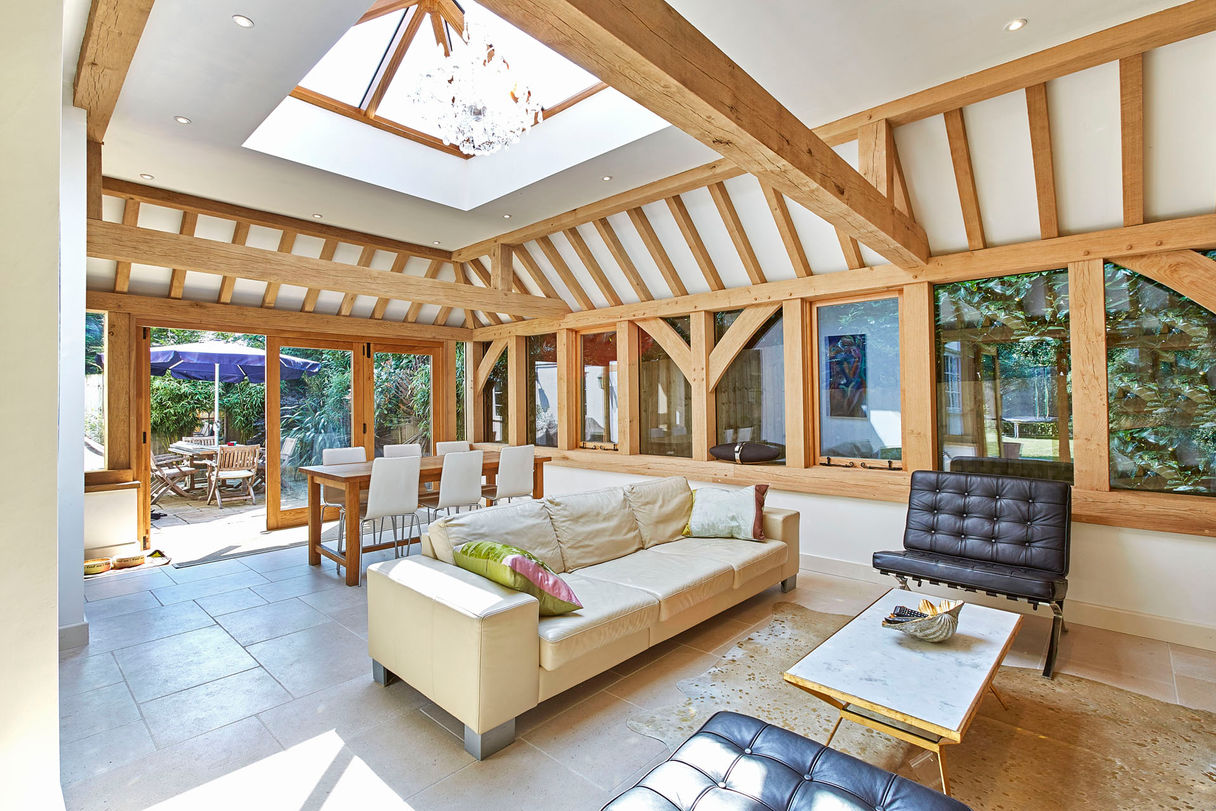 Bright living room with a skylight and wooden beams, highlighting the oak orangery by Hartwood Oak in Burghclere.