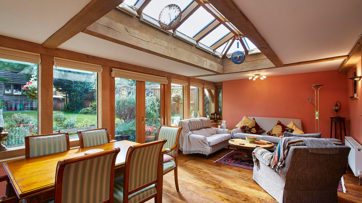A bright dining room featuring a skylight and a table, showcasing the oak orangery design by Hartwood Oak in Hungerford.