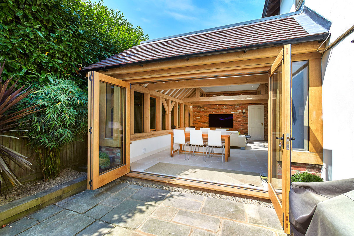 Charming patio and dining area outdoors, featuring an oak orangery by Hartwood Oak, located in Burghclere.