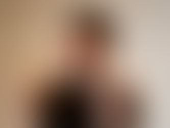 Blurred person holding head in distress, set against a plain background. Motion effect suggests anxiety or confusion.