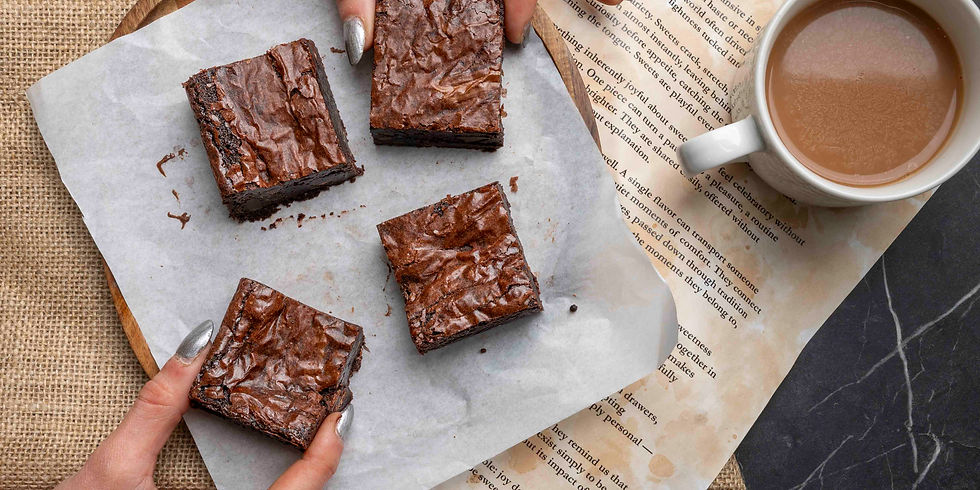 Overhead view of homemade chocolate brownies on parchment paper with a cup of coffee.