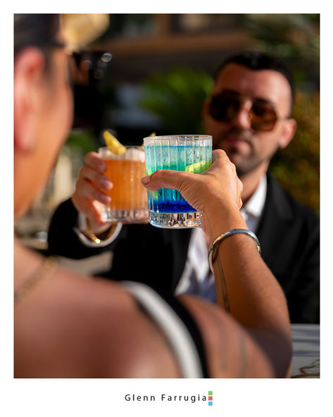 Friends toasting cocktails during lifestyle photography shoot in Malta
