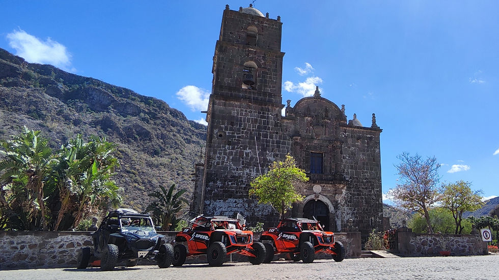 ATVs parked in front of a san Javier mission with mountains in the background the third day of a 3 day expedition