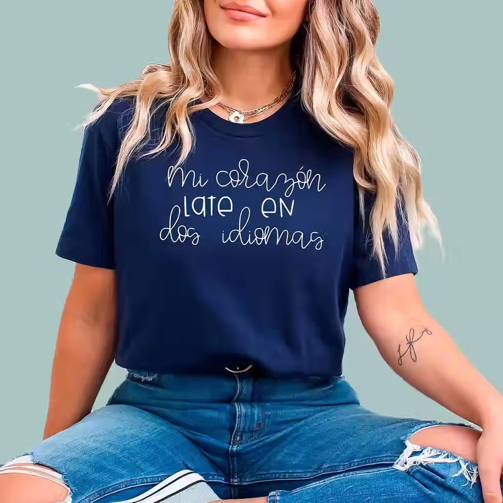 Navy blue cotton t-shirt with a heart and pencil graphic that reads 'Mi Corazón Late En Dos Idiomas' for bilingual teachers.