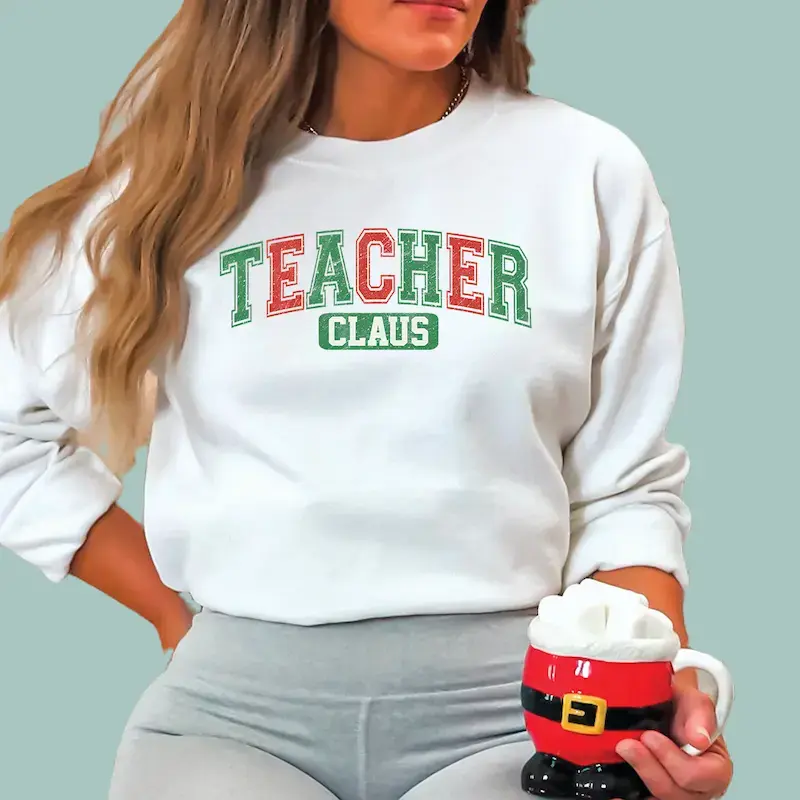 White cotton "Teacher Claus" graphic sweatshirt for the Christmas season.