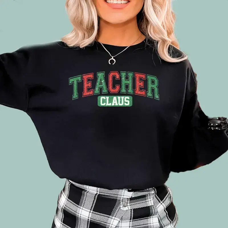 Black "Teacher Claus" Christmas sweatshirt for educators, featuring a festive holiday graphic.