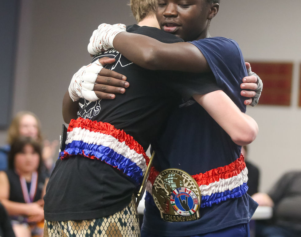 to teenage fighters hug it out after slugging it out in a kickboxing match at SAAMA Fight Night 7