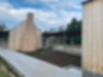Modern timber house construction with stone chimney and deck