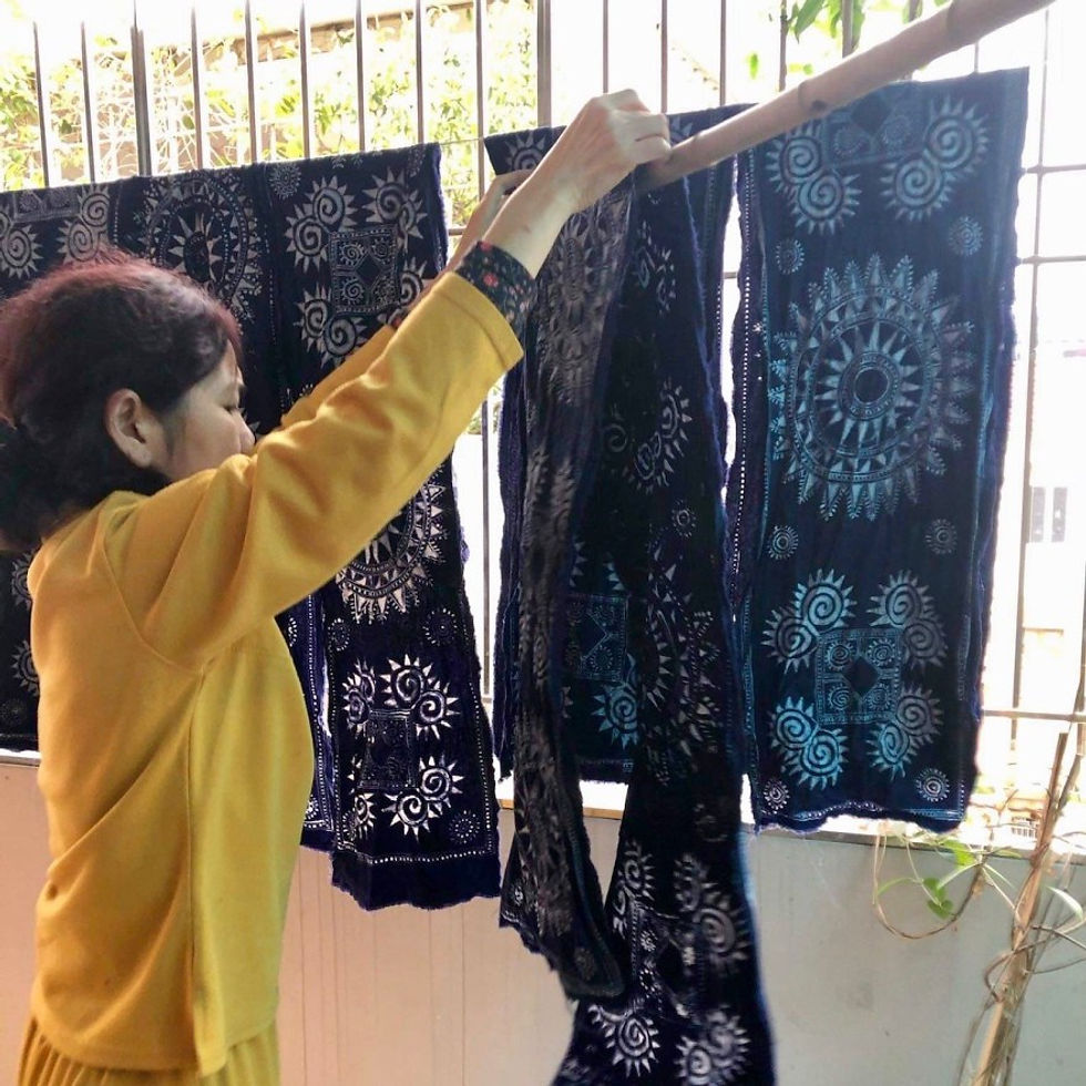 A photograph of traditional Vietnamese Hmong indigo dyed fabric bed-runners hanging up to dry. 
