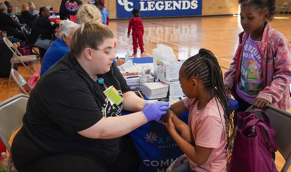 Health worker assisting a child at brain aneurysm community resources event.