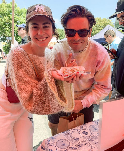 Smiling couple enjoying fresh Oma’s Poffertjes at an outdoor community event.