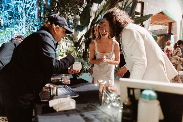 Guests smiling as Oma’s Poffertjes serves fresh, fluffy Dutch pancakes at a sunny outdoor wedding.