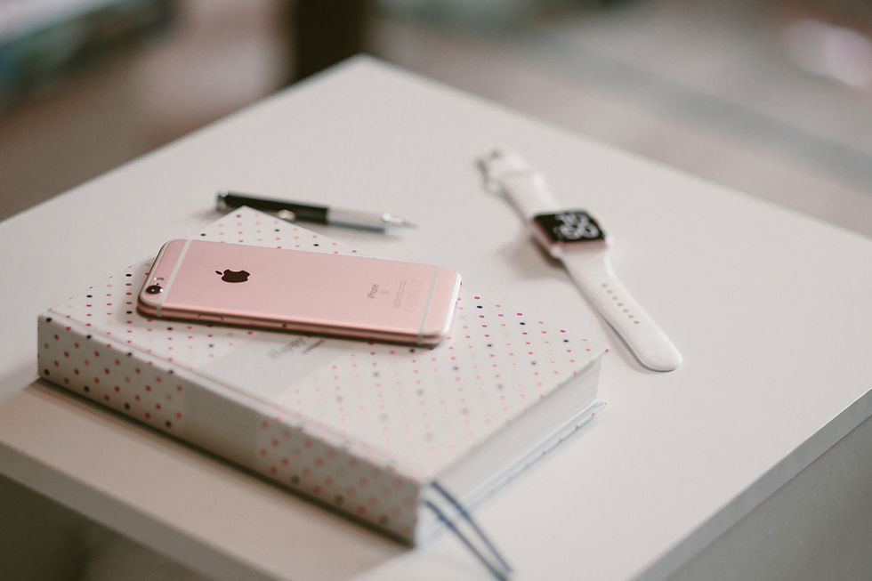 Journal, phone, pen, and an Apple Watch on a nightstand