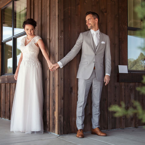 bride and groom hold hands around a corner, first touch, not seeing each other before the ceremony