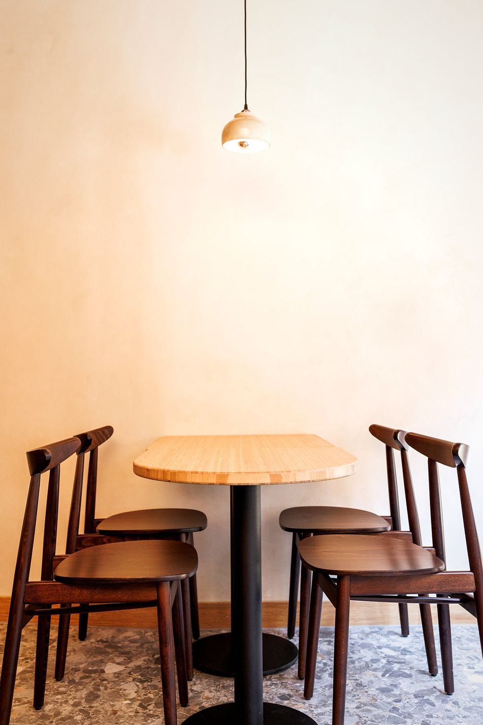Interieur van BODHI, vegan Aziatisch restaurant in Leuven: houten tafel onder hanglamp
