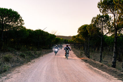 Group of motorcyclists riding along a scenic dirt road through the Algarve countryside