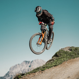 person riding on mountain bike on trail jumping