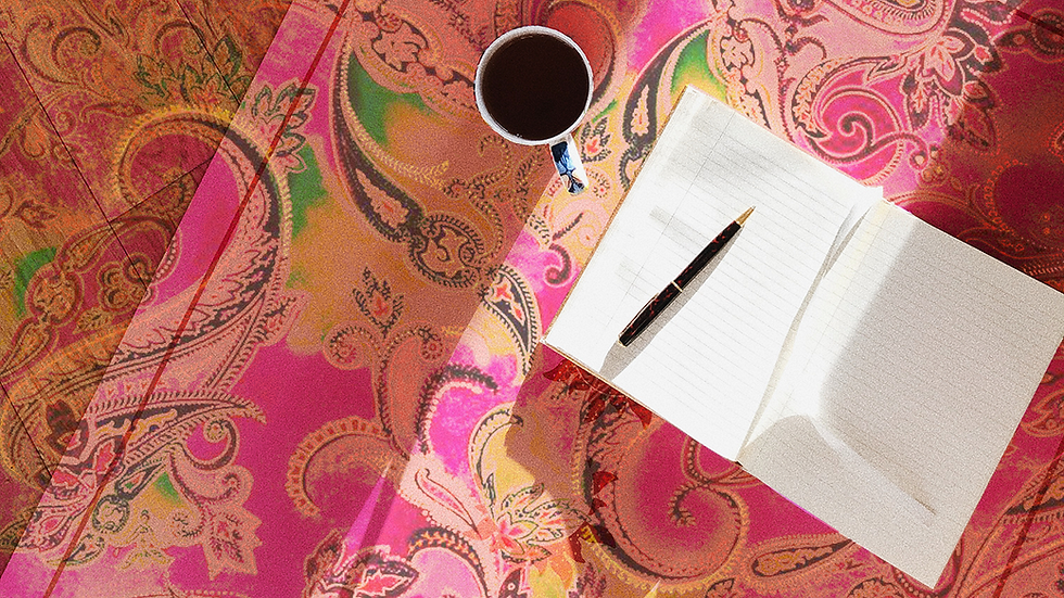 Person writing brand voice notes in a notebook for social media content outsourcing strategy.