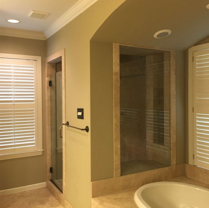 Fun turquoise primary bath, with Mexican encaustic patterned tile, white subway tiled walls, heavy glass, corner shower, large beveled glass mirrors, quartz countertops, crystal chandelier, blue walls, pineapple lighting sconces, dark shaker style cabinetry, French champagne plumbing fixtures