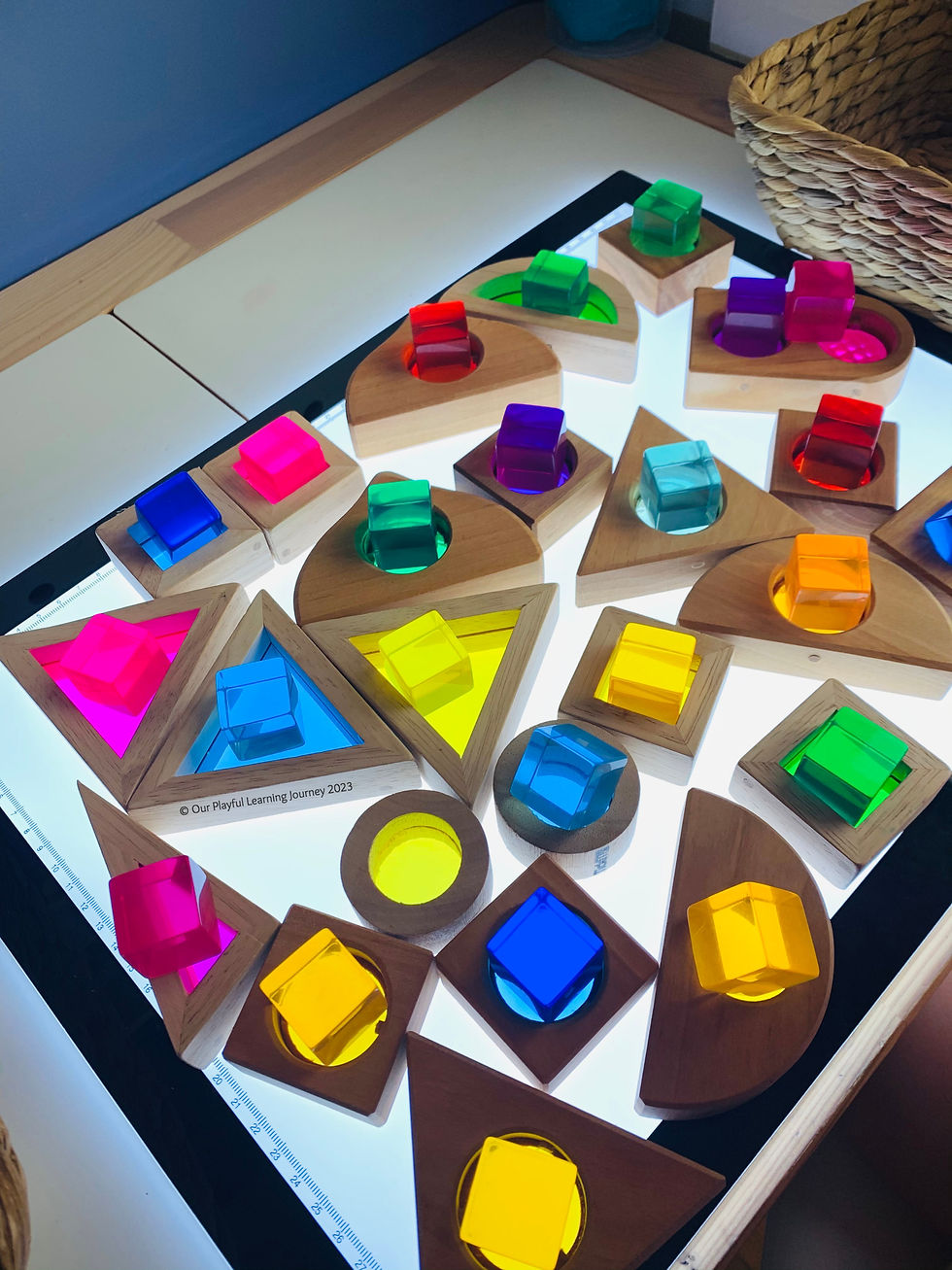 Colour matching on the light panel play idea for kids using rainbow blocks and lucite cubes.