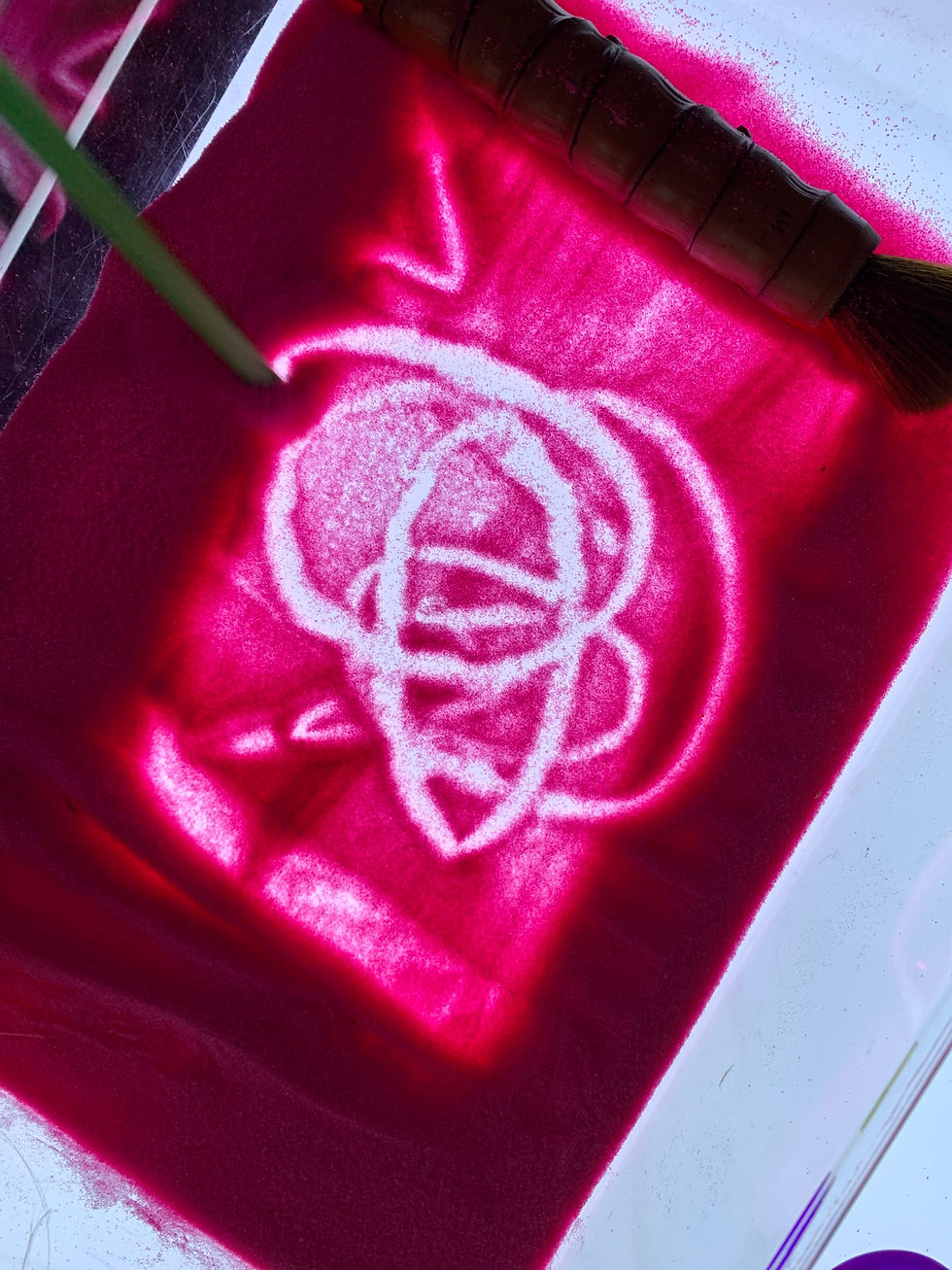 Light panel play idea for kids using a sand tray for mark making.