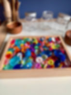 Kids play idea for loose parts. pretend Gems and jewels into plastic jars.