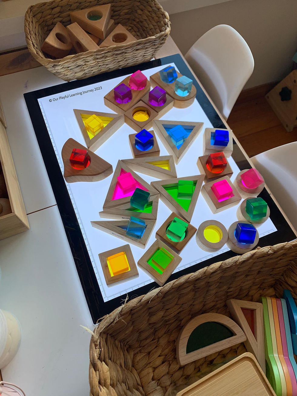 Light panel play idea for kids using rainbow blocks and lucite cubes.
