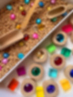 Play idea for kids to help learn about colours. Sensory play tray with chickpeas, coloured gems for colouring sorting.