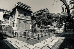 Foto in bianco e nero della struttura vista dall'esterno. Si osserva l'edificio, un piccolo giardino, il vialetto d'ingresso.