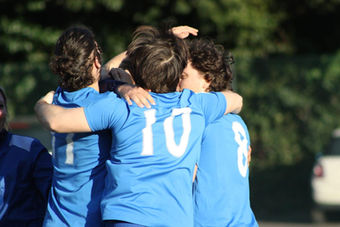 Tre atleti della squadra stretti in un abbraccio.