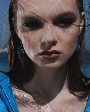 a close up of a woman 's face with a blue shirt on