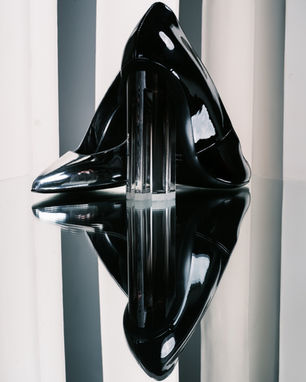 a pair of black shoes with a clear heel