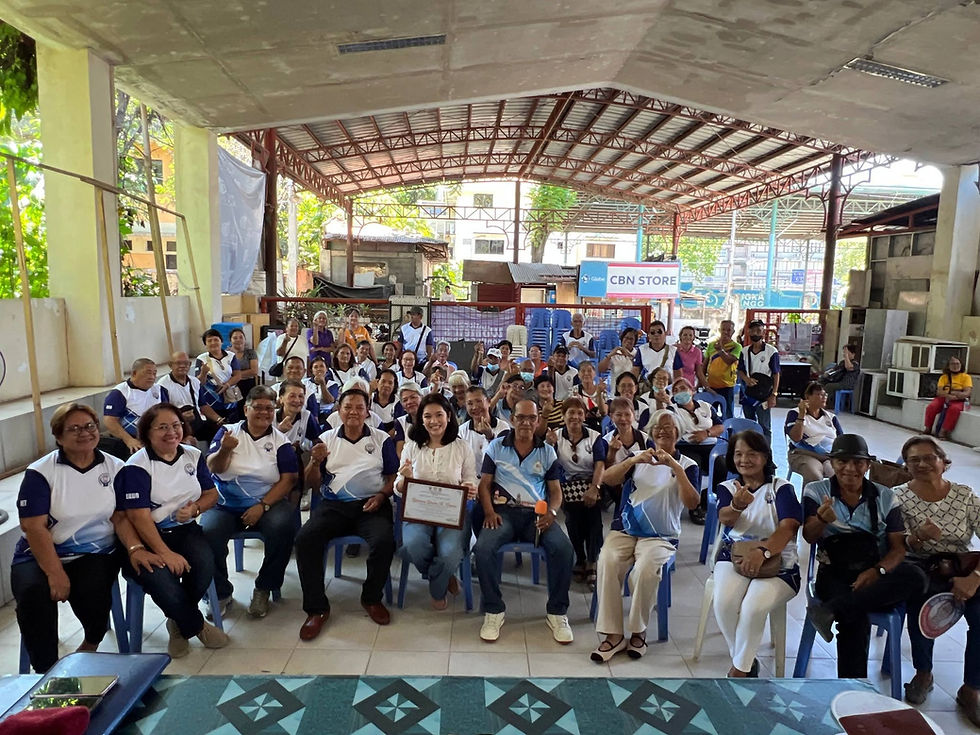 Senior citizens gather for group photo under pavilion with CBN STORE sign.
