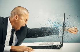 Homem com raiva socando a tela do notebook