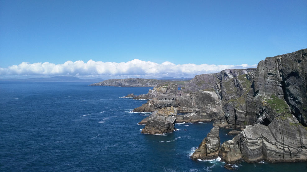 Cliff-face of Mizen Head, daytime, clouds in distance.