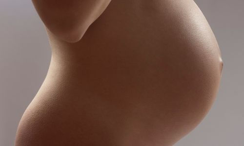 Donna in gravidanza che si accarezza il ventre, esempio di come cambia il corpo in gravidanza durante la maternità.