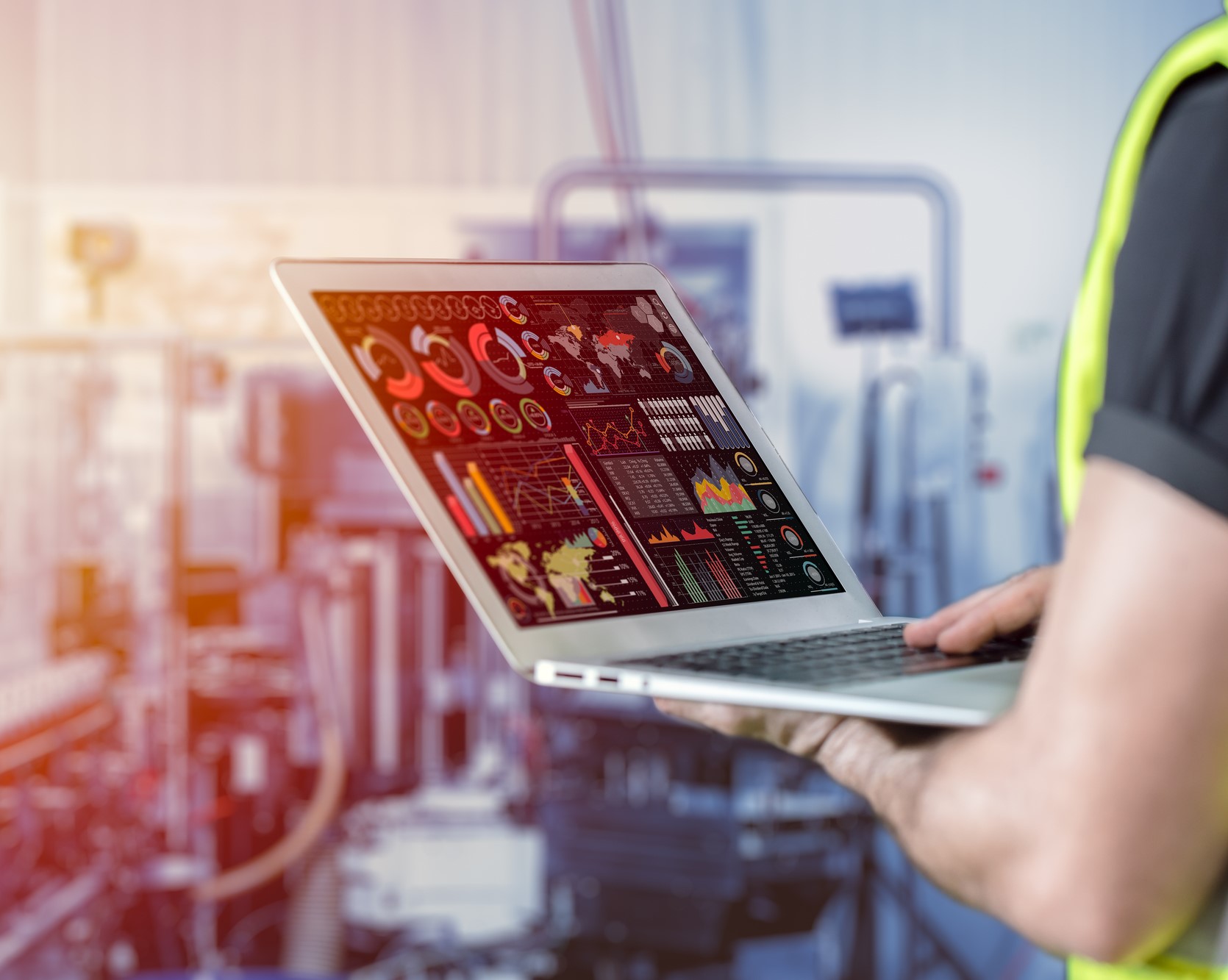 A laptop displaying complex data collection & reporting, suggesting a focus on data-driven insights in a manufacturing environment.